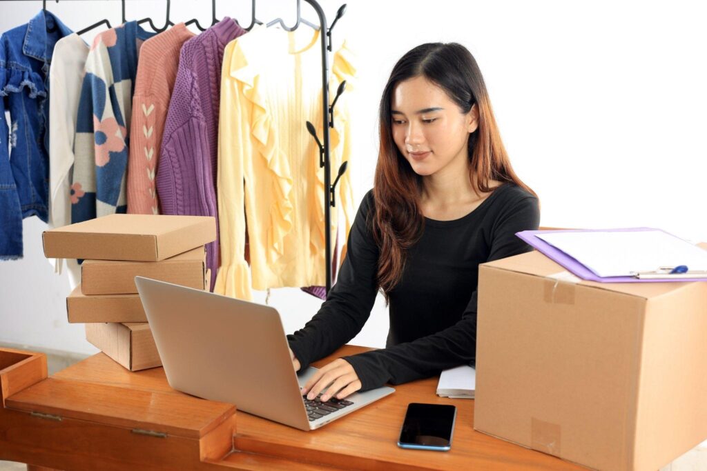 A woman managing the inventory of her clothing retail store on her laptop