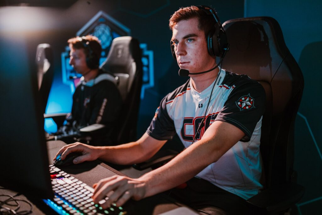 An esports player wearing a headset competing at a gaming PC